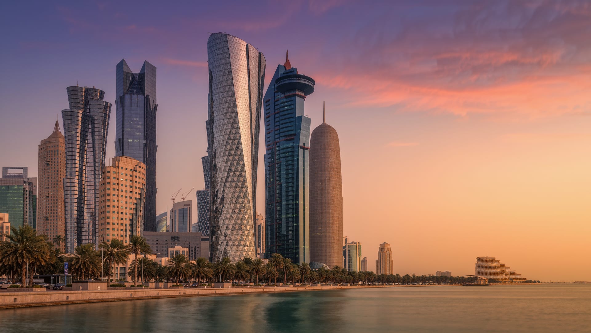 The Riyadh skyline at sunset above the palm-lined corniche